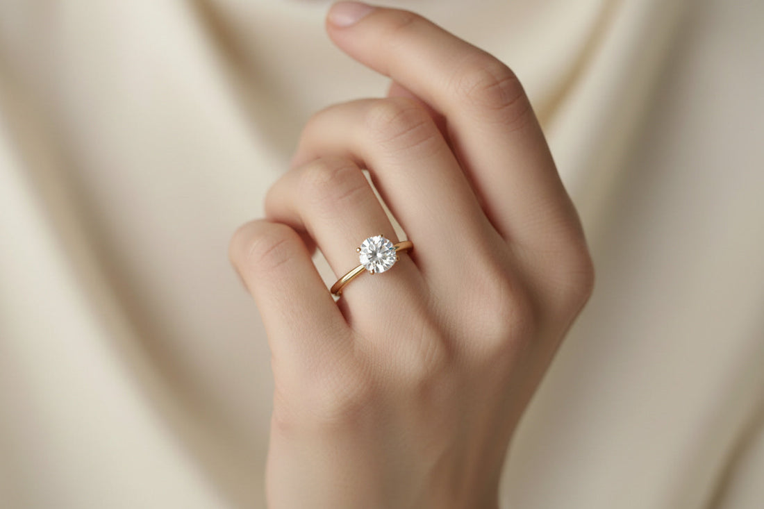 1 carat round brilliant diamond solitaire engagement ring on size 5 finger in 18K yellow gold thin band — elegant fine jewelry by JewelryRich