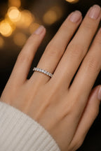 Full eternity diamond band in 18K white gold worn on hand against dark background, brilliant-cut diamonds all around, JewelryRich