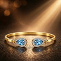 18K Yellow Gold Open cuff Bangle with Pear-cut Blue Topaz Stones in a Diamond  Halo setting