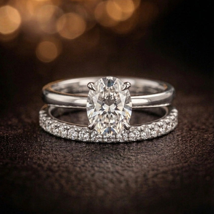 Silver ring with a large diamond and smaller diamonds on a dark background