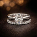 Silver ring with a large diamond and smaller diamonds on a dark background