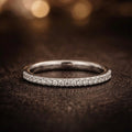 White gold ring with small diamonds on a dark background
