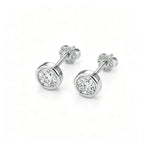 Pair of bezel-set diamond stud earrings in 18K white gold, front view on white background
