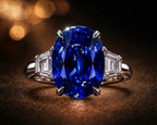 Vivid blue oval sapphire ring with trapezoid diamond side stones in platinum — investment-grade colored gemstone