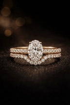 Oval solitaire diamond engagement ring paired with contoured pavé wedding band in 18K rose gold — bridal ring set | JewelryRich