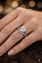 Hidden halo diamond engagement ring and contoured pavé band bridal set worn on hand — 18K white gold round brilliant center stone — JewelryRich
