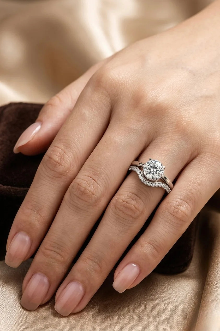 Hidden halo diamond engagement ring paired with contoured pavé wedding band worn on hand, 18K white gold bridal set, JewelryRich