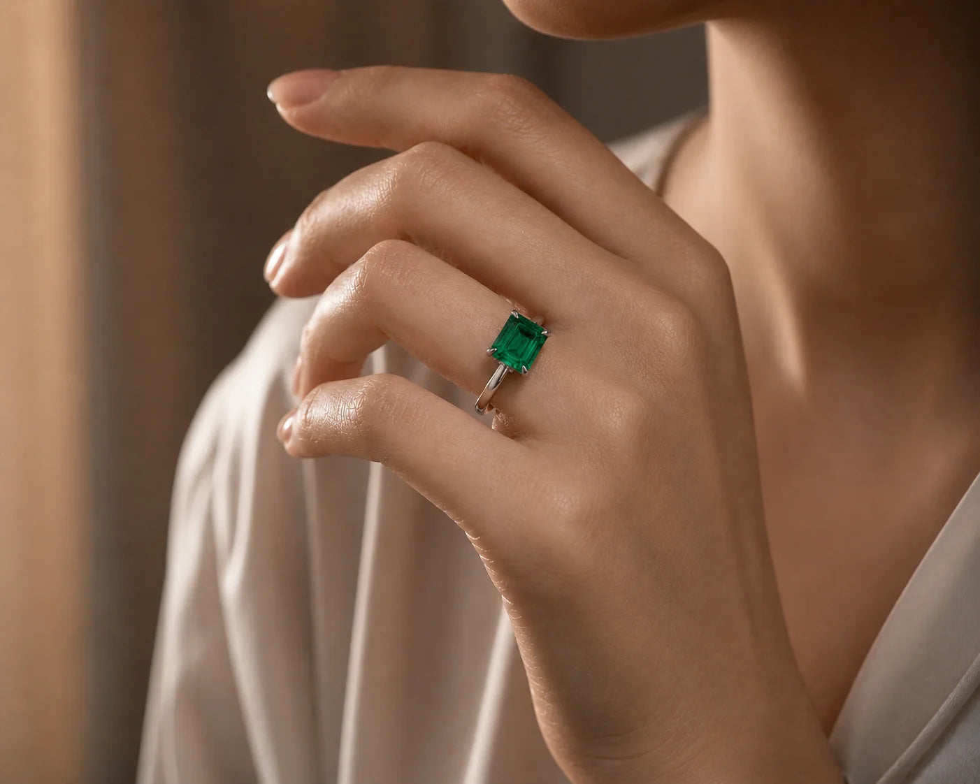 Natural Colombian emerald solitaire ring worn on hand, vivid green emerald-cut stone, platinum setting, JewelryRich fine jewelry