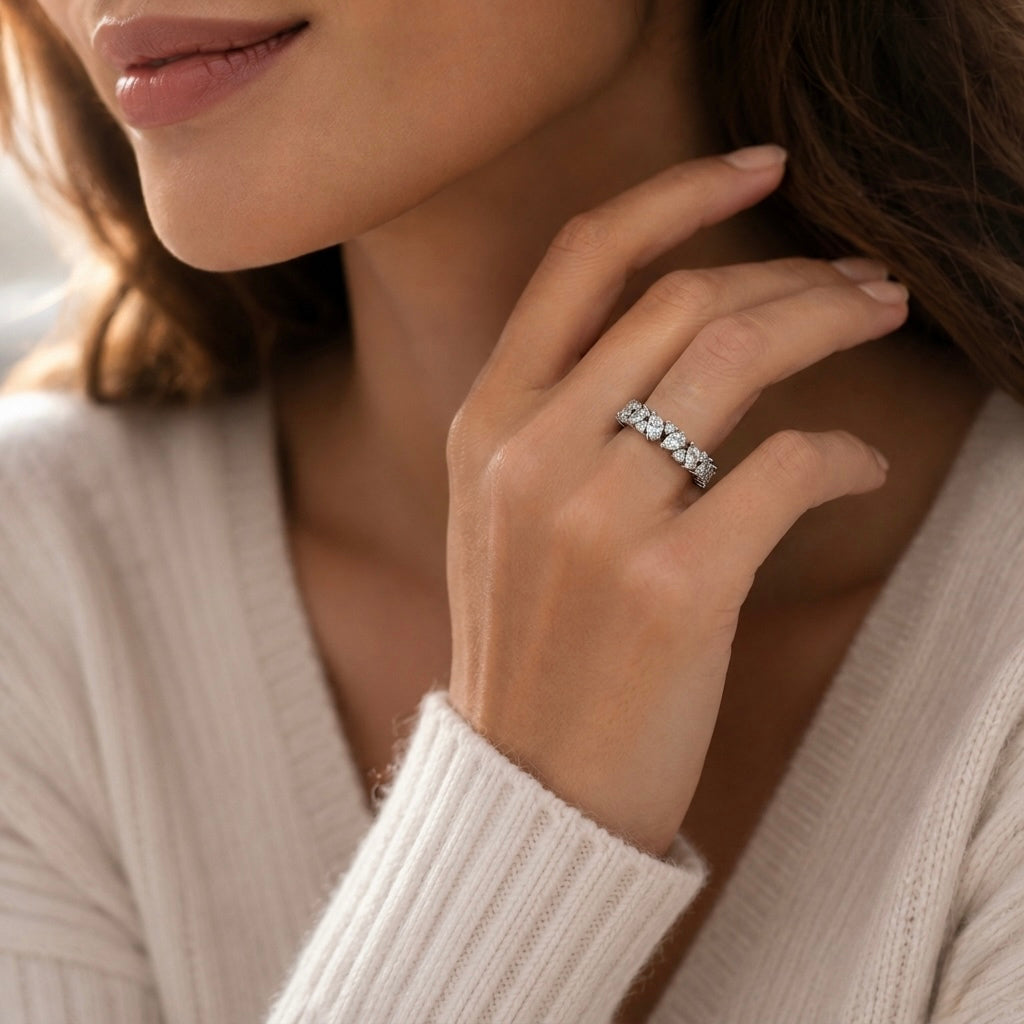 Diamond band ring with alternating round and pear cut diamonds in 18K white gold worn on hand – elegant lifestyle | JewelryRich