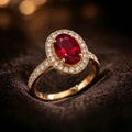 Oval ruby halo ring in 18K yellow gold – dramatic dark background editorial photography | JewelryRich