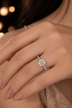 Pavé band solitaire diamond engagement ring worn on hand — 18K white gold with round brilliant center stone — JewelryRich